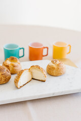choux cream or cream puff or French profiteroles with fresh cream set on cafe table with antique colored cup