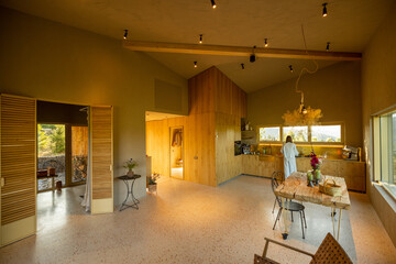 Spacious kitchen with wooden cabinetry and large windows, offering views of the surrounding nature