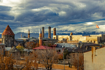 Historic skyline of Erzurum featuring castle, clock tower, madrasa, and mosques.