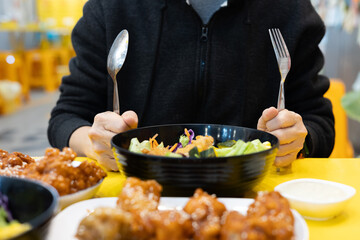 Close-up of woman eating salad in black bowl