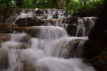 Fototapeta premium Travel to waterfalls during the rainy season, The tiers of the waterfall contrast beautifully with the sky