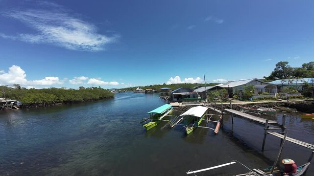 A serene aerial view of Day-asan floating village with wooden boats and houses under a clear blue sky