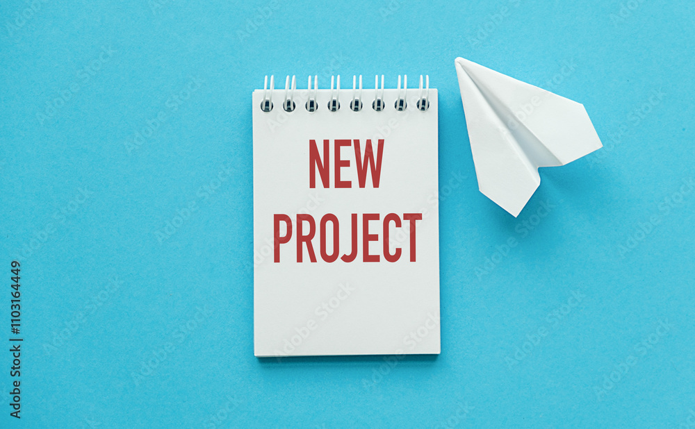 Poster new project text on note pads on blue background with notebook and paper airplane
