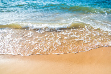 Serene Ocean Waves Gently Caressing Sandy Beach Shoreline in Golden Sunlight