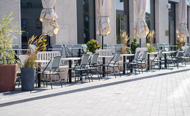 Empty cafe tables on the street concept of business closing or opening