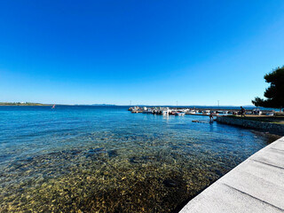 Obraz premium Serene coastal view with boats under a clear blue sky