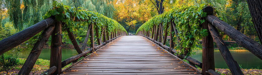 Obraz premium serene wooden pedestrian bridge surrounded by lush greenery and autumn colors
