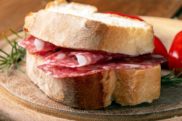 Primo piano di un panino imbottito con salame toscano, spuntino italiano, cibo europeo 