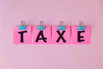 Taxe text on a pink sticker and on pink background.