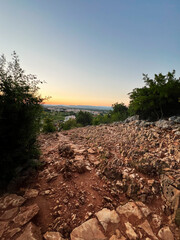 Fototapeta premium Beautiful sunset over rocky landscape and distant horizon view. Apparition Hill, Medjugorje, Bosnia and Herzegovina.
