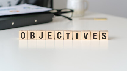 Word writing text OBJECTIVES on wooden cubes. Business concept on the office desk