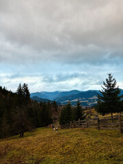 Scenic mountain landscape with vast sky and rustic fencing. Carpathian mountains, Ukraine.
