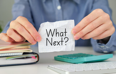 Female hand showing What's next? text on paper notepad.