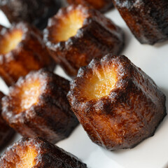 Caneles de bordeaux, traditional French sweet dessert with white table background, High quality photo