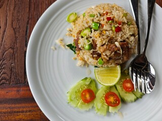Fried rice with pork and vegetables on white plate. Thai food