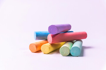 Crayons of different colors arranged on a white background. Education