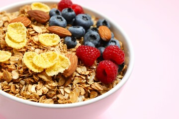 Delicious granola with berries on a color background
