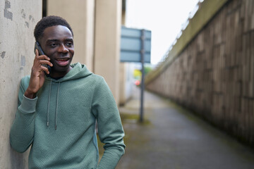 Teenage Boy In Concrete Urban City Setting Talking On Mobile Phone