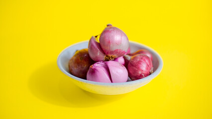 red onion in white bowl on yellow background 