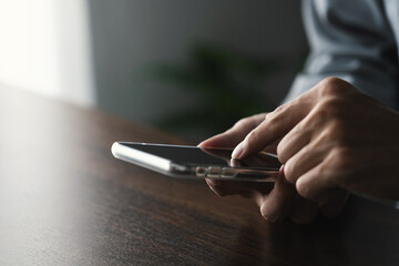 Close up hands using cellphone browsing on internet