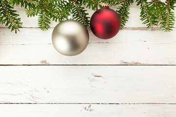 Christmas background with fir twigs and baubles border on white painted wood