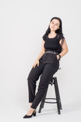 Fototapeta premium Cute young brunette girl sitting on a white background. Copy space