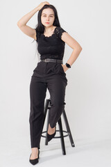 Cute young brunette girl sitting on a white background. Copy space