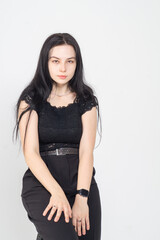 Fototapeta premium Cute young brunette girl sitting on a white background. Copy space