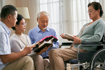 group of senior asian people reading bible together