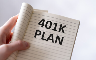 Paper with text 401k plan on a financial table with eyeglasses and metal pen