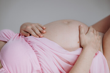 Zbliżenie na ciężarny brzuch młodej mamy