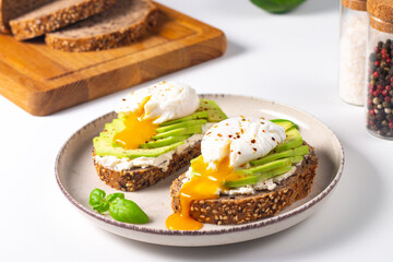 Two avocado open sandwiches with egg. Keto and diet concept. Healthy toast food for breakfast.