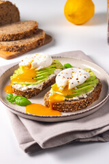 Two avocado open sandwiches with egg. Keto and diet concept. Healthy toast food for breakfast.