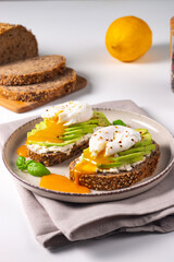 Two avocado open sandwiches with egg. Keto and diet concept. Healthy toast food for breakfast.