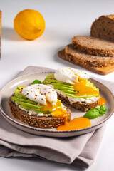 Two avocado open sandwiches with egg. Keto and diet concept. Healthy toast food for breakfast.