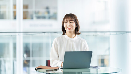 デスクワークをする笑顔の女性・ビジネスウーマン