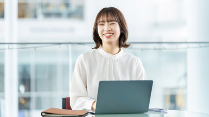 デスクワークをする笑顔の女性・ビジネスウーマン