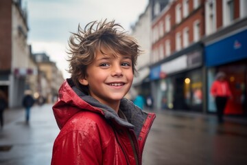 Portrait of a smiling boy in red jacket on a city street