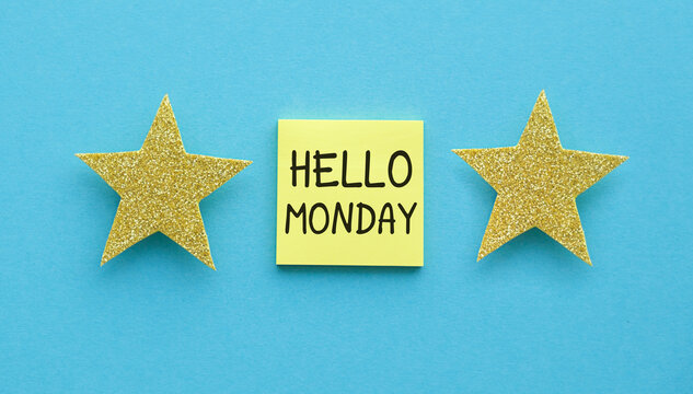 Hello Monday text on a paper note and star figurines on a blue background