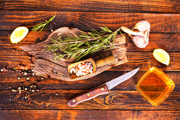 Rosemary sprig on a wooden kitchen table.