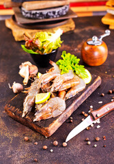 Shrimps Prawns skewers with herbs, garlic and lemon on black stone background,
