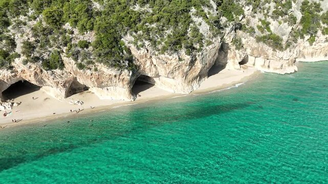 Aerial view of grottoes and beautiful turquoise beaches with clear water and cliffs, Dorgali, Italy.
