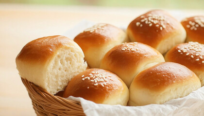 Freshly baked dinner rolls sprinkled with sesame seeds in a basket