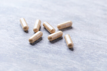 Korean Ginseng capsules. Concept for a healthy dietary supplementation. Wooden background. Soft focus. Close up.	