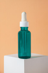 Blue glass cosmetic bottle, Skin care or sunscreen cosmetic with stylish props on cream background.