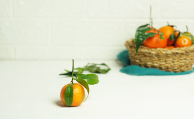 Ripe tangerines with leaves on the kitchen table