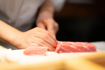 Sushi chef slicing red tuna at an omakase restaurant in Tokyo