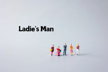 A miniature model group of handsome man and women is located on a white background. Relationship between man and woman.