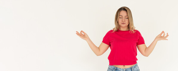 Mindful peaceful woman meditates indoor, keeps hands in mudra gesture, has eyes closed, tries to...