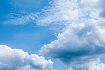 Fluffy, bright clouds and blue summer sky background.